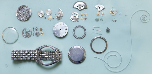 Parts of deconstructed watch lying on table