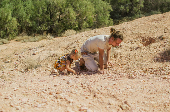 Father and child looking for fossils in limestone