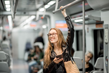 Lifestyle portrait of a young businesswoman standing with smart phone at the modern train