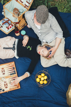 Spring Picnic - Overhead of Romantic Couple on Blue Quilt Enjoying the Outdoors