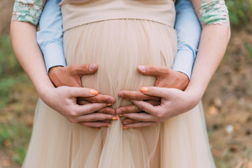 heart of the hand on the belly of a pregnant woman
