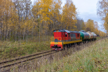 Obraz premium old locomotive with tanks in the autumn forest
