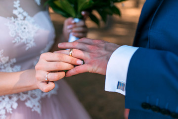 the bride puts on the wedding ring the groom of the hand