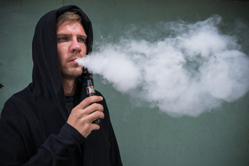 Man with vape. Young man smoking an electronic cigarette