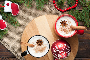 eggnog cocktail in  mug arranged with christmas decoration on wooden table