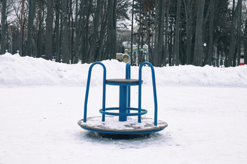 Winter landscape. On the ground in the park lies the snow. Frosty air. Little Carousel.