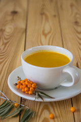 Vitaminic tea with sea-buckthorn on the wooden table