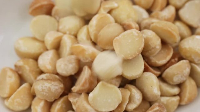 Video of macadamia nuts slowly spilling into a bowl.
