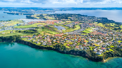 Aerial view on residential suburbs surrounded by sunny ocean harbour. Whangaparoa peninsula,...