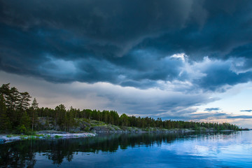 Thunderclouds. Weather spoils. Karelia. Russia. Ladoga lake. Evening in Karelia on the shore of the Ladoga lake.