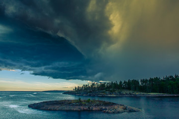 Stormy weather. Clouds with a thunder-storm. Unusual sky. Karelia. Russia. Ladoga lake. Evening in Karelia on the shore of the Ladoga lake. Wild nature.