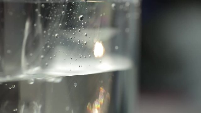 Closeup shot of pouring water from bottle into glass.
