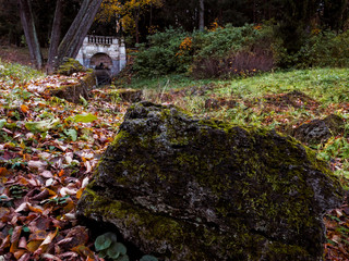 Artificial waterfall in an autumn park. Yellow leaves on the shores