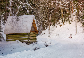 woodshed by the road in winter forest. lovely nature scenery
