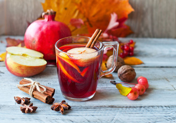 Mulled wine, grog in a glass with cinnamon and fruit, autumn decor and drink

