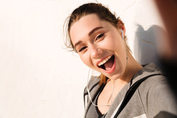 Close-up of happy young pretty sport woman, looking at camera with open mouth