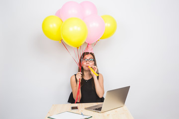 Funny young woman celebrating the success of her business or a birthday in the office holding...
