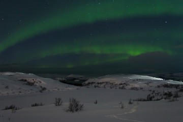 Snow covered the hills and in the sky stars, clouds and northern lights.