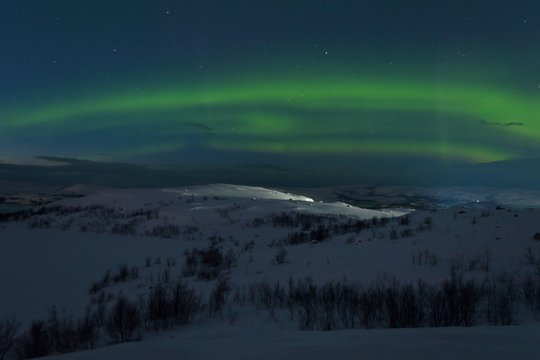 Snow covered the hills and in the sky stars, clouds and northern lights.