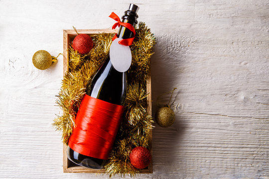 Image of bottle of wine in box with tinsel, Christmas balls
