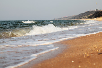 Stormy sea background.Waves and splashes.Sandy beach.