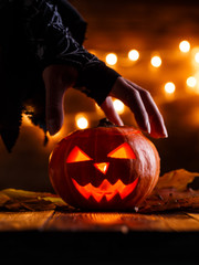 Image of halloween background with pumpkin and witch hand