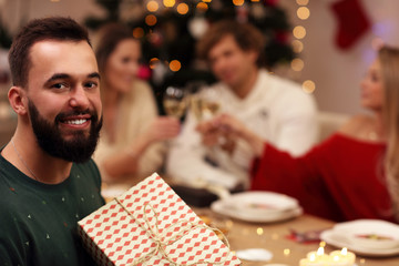 Group of friends giving Christmas presents at home