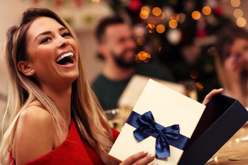 Group of friends giving Christmas presents at home
