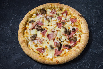 Pizza Carbonara on black stone background. Italian Pizza Carbonara with Bacon, mushrooms and Cheese