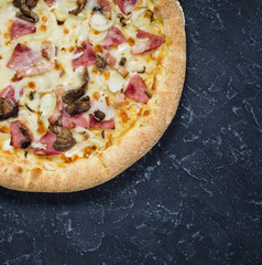 Pizza Carbonara on black stone background. Italian Pizza Carbonara with Bacon, mushrooms and Cheese close up.