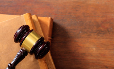 Judge gavel on law books, wooden desk, top view