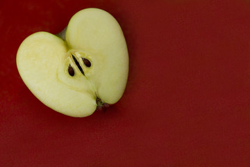 half of a yellow apple lies on a red background