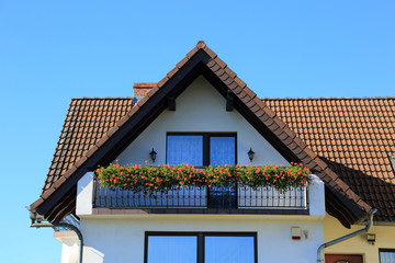 Balkon z kwiatami w domu jednorodzinnym. - obrazy, fototapety, plakaty