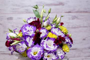 Blue and white lisianthus eustoma flower bouquet n a white wooden background