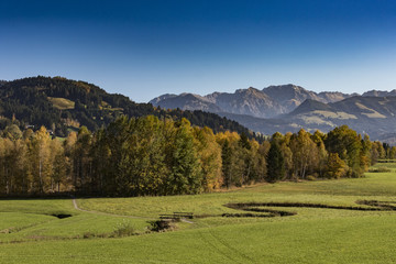 Voralpenland mit Bach und Wanderweg im Herbstwald