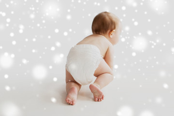 little baby in diaper crawling on white floor