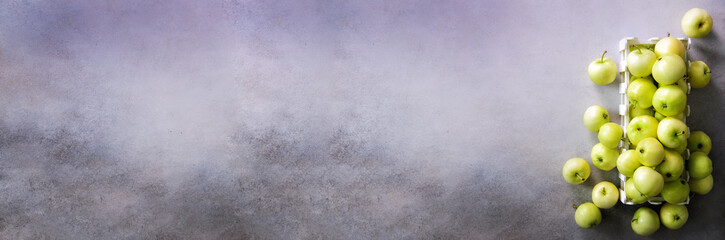 Fresh green apples in wooden box on light grey background. Free space for text. Copy space. Top view. Banner