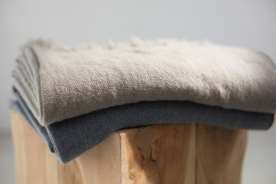 Close up of two wool blankets on a wooden stool