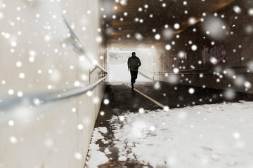man running along subway tunnel in winter