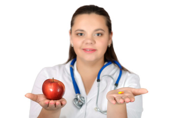 A doctor  holds an apple and capsule.