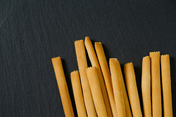 bread sticks on black stone surface