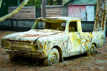 An old rusty car in paint from paintball.