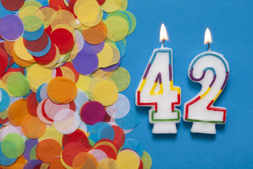 Number 42 celebration candle with party confetti