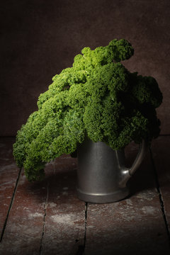 Kale in vintage pewter can in dark moody light