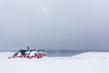 Old red building among the snow at the fjord, Nuuk Greenland