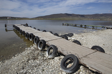 The longest pier on the pond with old car tires. Recreation area in Georgia.