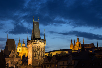 View of lit Lesser Town Bridge Towers, St. Nicholas Church and Prague (Hradcany) Castle at the Mala Strana (Lesser Town) in Prague, Czech Republic, in the evening. Copy space.