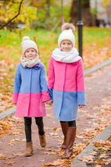 Little adorable girls outdoors at warm sunny autumn day