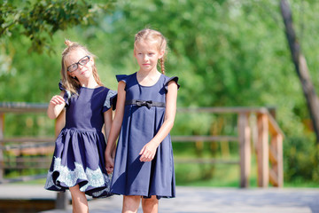 Adorable little school girls outdoors in fall