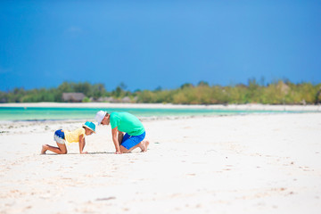 Family of father and kid on white sandy beach
